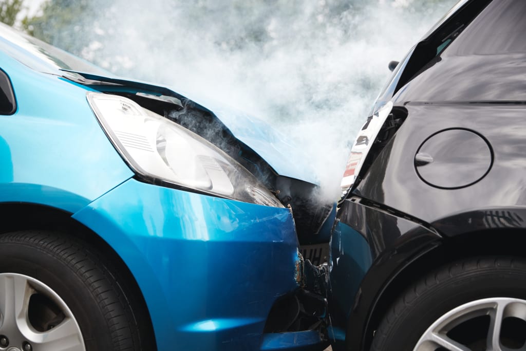 Close-up of two cars in a rear-end collision with smoke